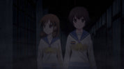 Two animated characters in school uniforms standing in a dark hallway.