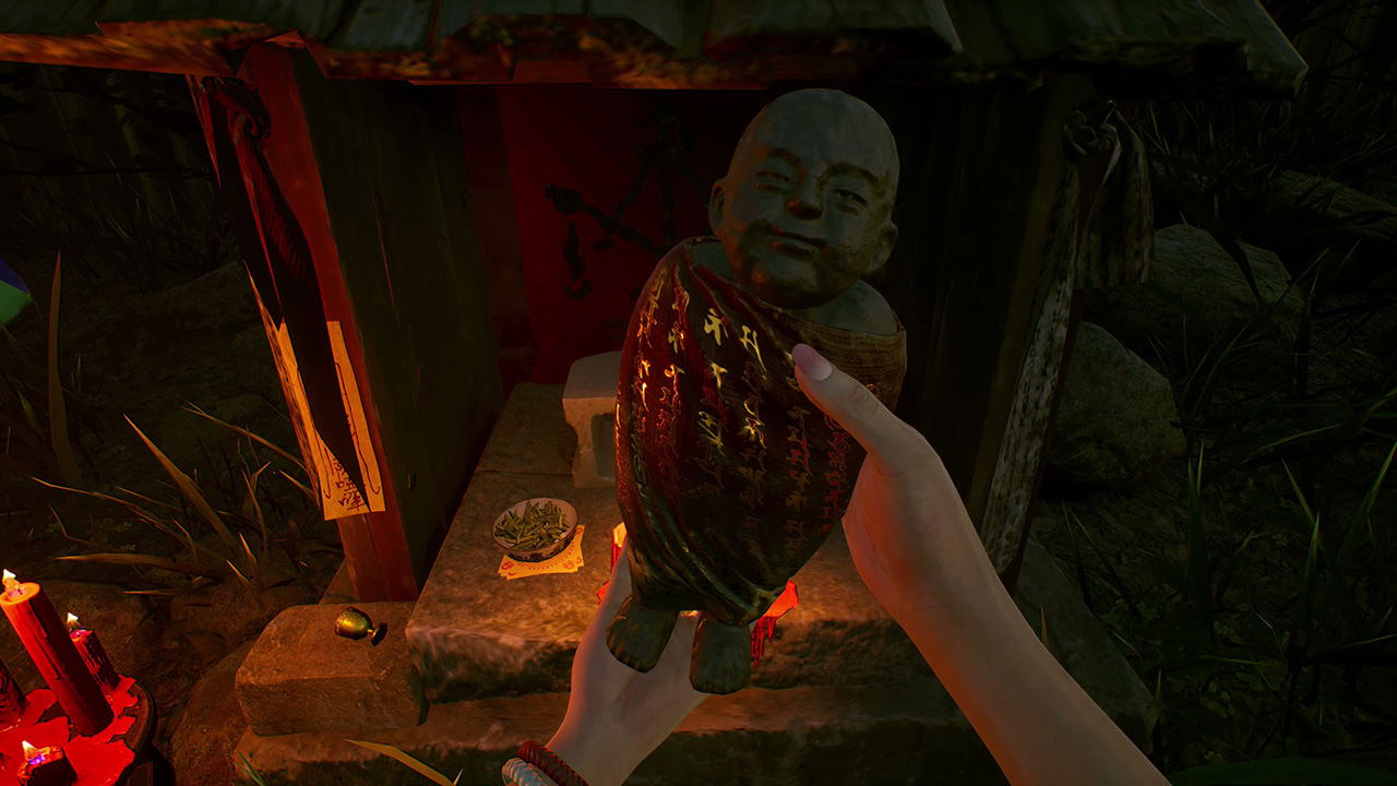 Hand holding a large fruit towards a statue in a dimly lit room with candles and a table.