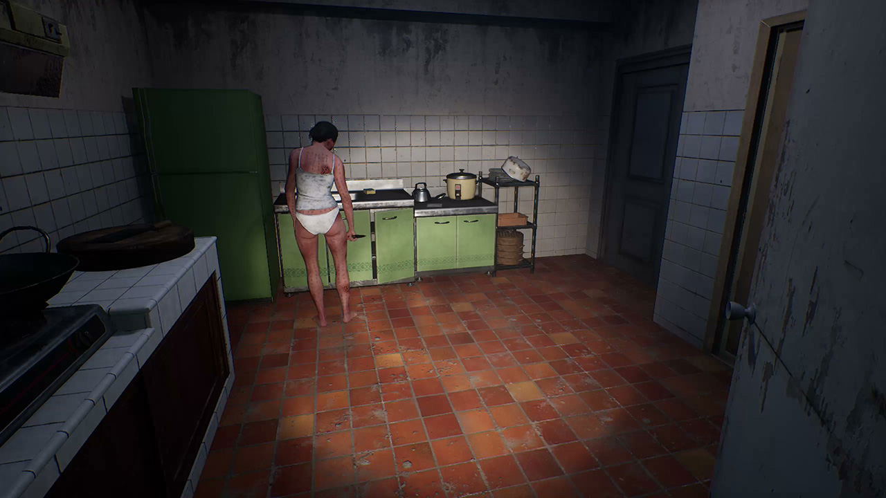 Person in a kitchen with green cabinets and tiled walls