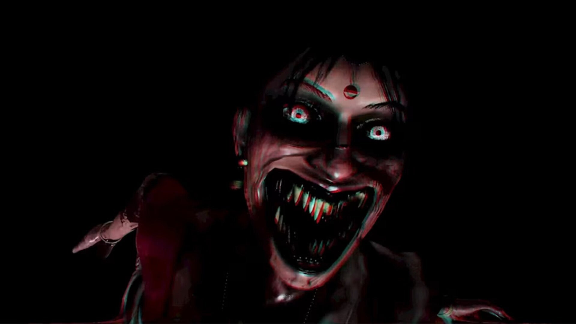 A dark, horror-themed close-up of a menacing face with glowing white eyes, a red forehead mark, and an open wide grin showing sharp teeth, set against a solid black background.