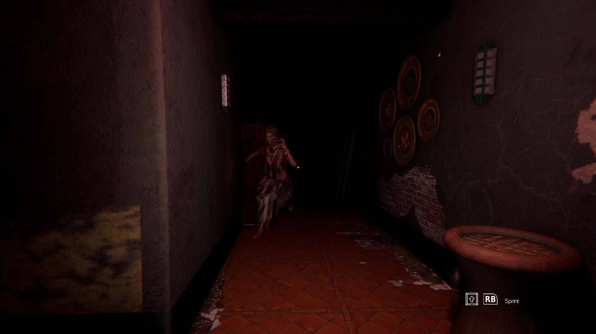 A dimly lit video game scene showing a player character running down a dark hallway with red-tiled flooring, textured walls, circular wall decorations, and a small table in the foreground.