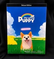 Deluxe Edition box art for the board game 'My Little Puppy' featuring a cartoon puppy in a grassy field under a blue sky with a rainbow and white clouds.