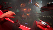 First-person shooter game scene with a hand holding a gun and a futuristic environment.
