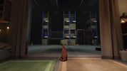 A small orange tabby cat sits on a tiled floor in a dimly lit room, looking out toward a large warehouse or storage area with tall blue shelving and stacked boxes.