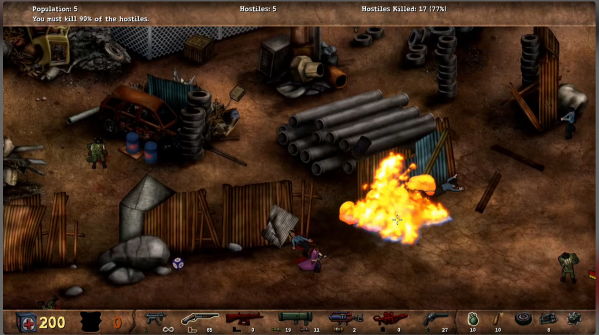 A screenshot from a top-down strategy game showing a base interior with pipes, crates, wooden barricades, and a bright explosion in the lower-right area.