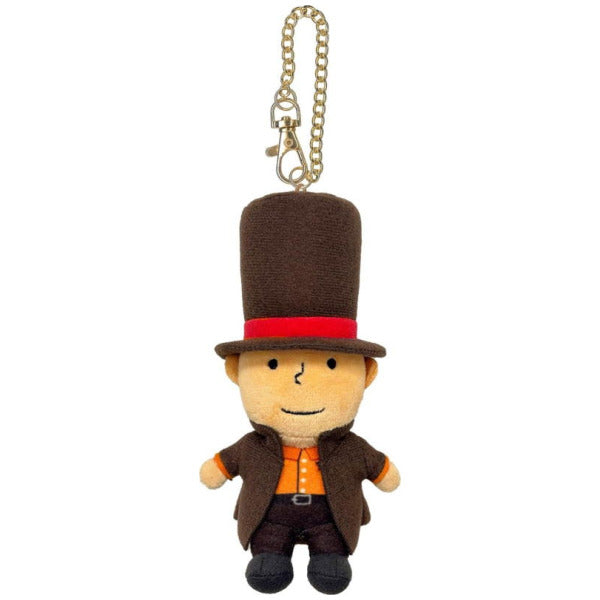 A small plush character keychain or bag charm with a tan face, wearing a tall brown top hat with a red band, a brown coat, and an orange shirt, attached to a gold chain on a plain white background.