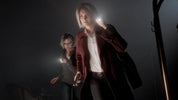 Two people in dark clothing with flashlights in a dimly lit setting
