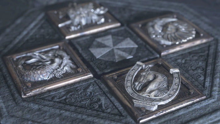 Collection of silver medallions with various designs on a textured surface
