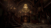 Dark, ornate interior with a grand staircase and chandelier