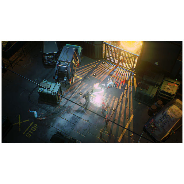 A top-down video game scene showing a character standing on a metal walkway in an industrial alley with vehicles, crates, and bright explosions or light effects.