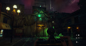 A dark, atmospheric video game scene showing a first-person view with a mounted camera or device in the foreground, facing a wooden structure with glowing green lights and a streetlamp on the left.