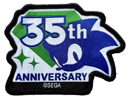 A 35th Anniversary embroidered patch featuring Sonic the Hedgehog artwork, with white '35th' text over green and blue sections, 'ANNIVERSARY' at the bottom, and a black stitched border. A small '©SEGA' mark is visible near the bottom edge.