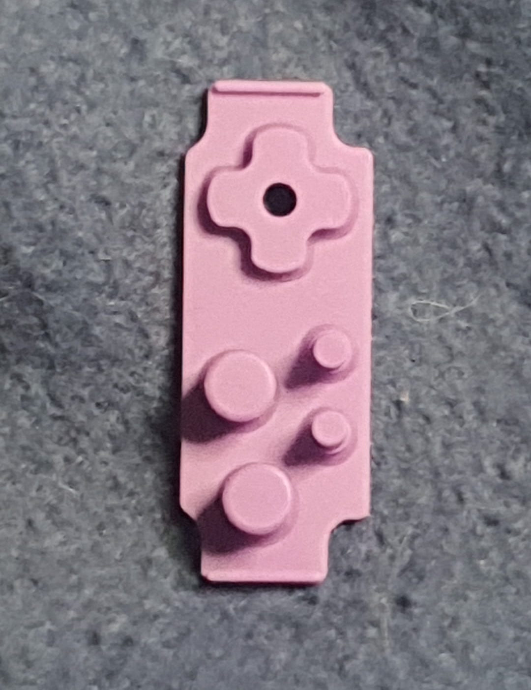 Pink building block piece on a gray surface