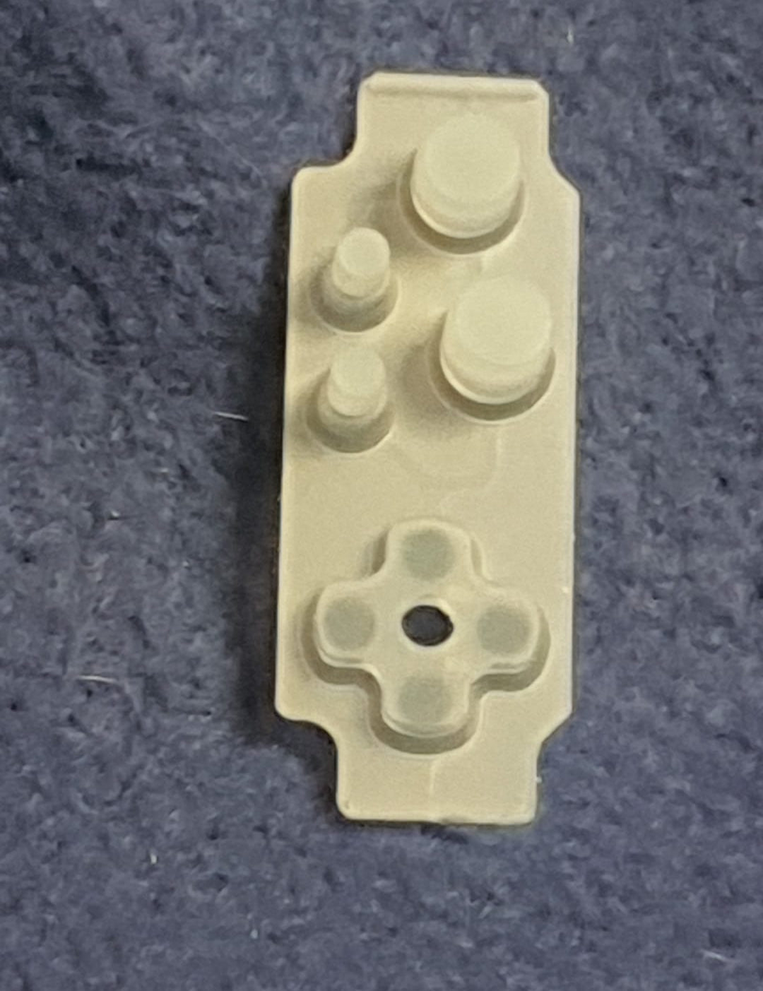 White plastic component on a textured gray background