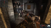 First-person shooter game scene with character holding a gun in a dimly lit room.